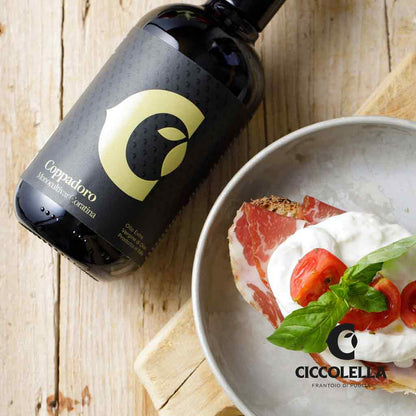 Olivenölflasche Coppadoro, Brot mit Schinken, Tomaten, Basilikum.