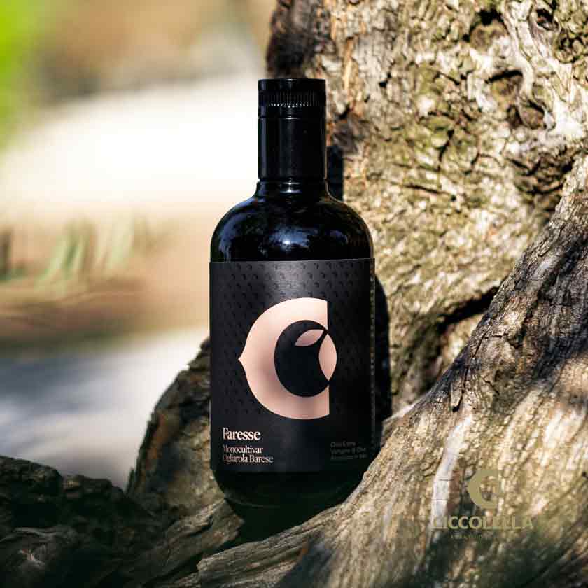 Flasche Faresse Olivenöl auf Baumstamm im Freien.