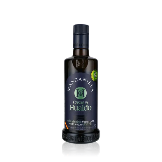 Casas de Hualdo Manzanilla Olivenöl Flasche auf schwarzem Hintergrund.