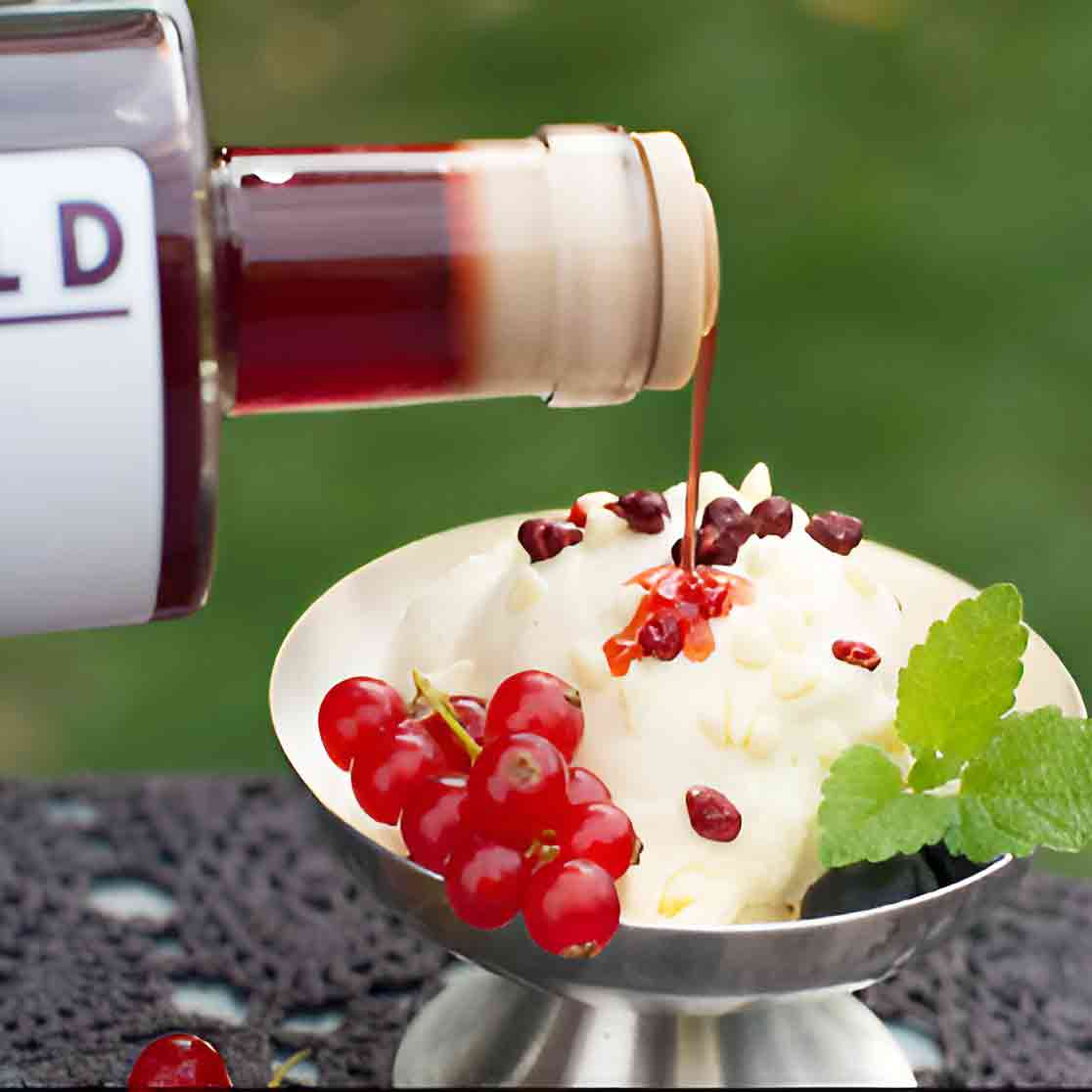 Eiscreme mit Johannisbeeren und Essig in Metallschale.