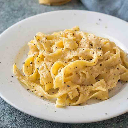 Fettuccine auf Teller mit Pfeffer bestreut.