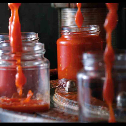Tomatensauce wird in Gläser abgefüllt.