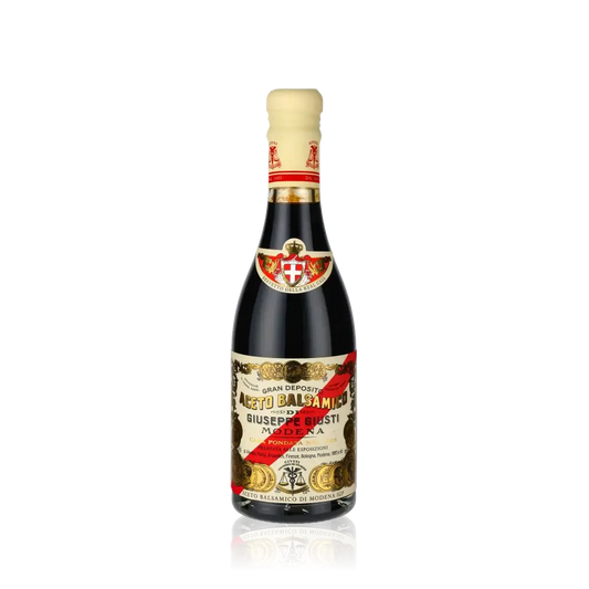 Giuseppe Giusti Aceto Balsamico Flasche auf schwarzem Hintergrund.