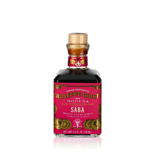 Flasche Giuseppe Giusti Saba Balsamico-Essig vor schwarzem Hintergrund.