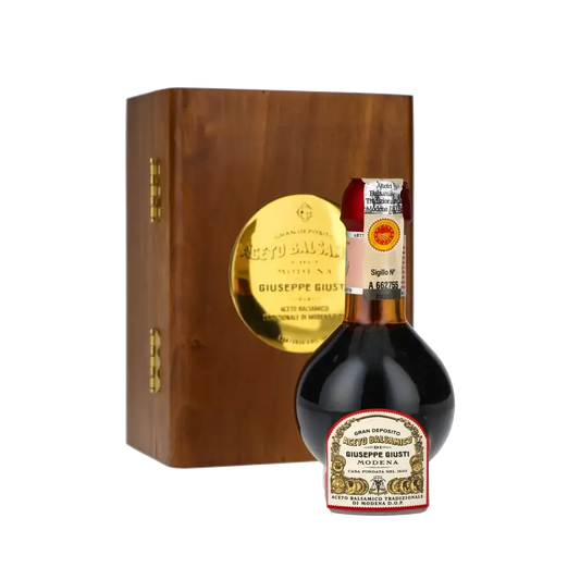 Giuseppe Giusti Balsamico-Essigflasche vor Holzkiste.