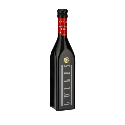 Gölles Rotweinessig Flasche vor schwarzem Hintergrund.