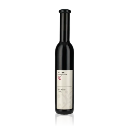 Flasche Acetum Manufaktur Aperitif-Essig vor schwarzem Hintergrund.