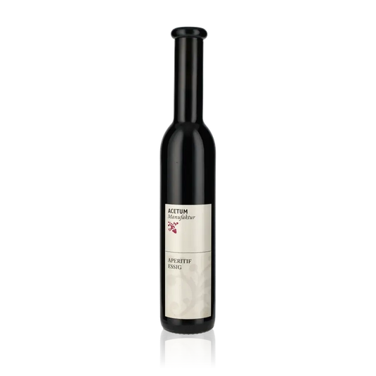 Flasche Acetum Manufaktur Aperitif-Essig vor schwarzem Hintergrund.