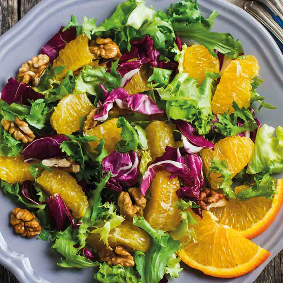 Orangen-Walnuss-Salat mit Feigen-Dressing auf grauem Teller.