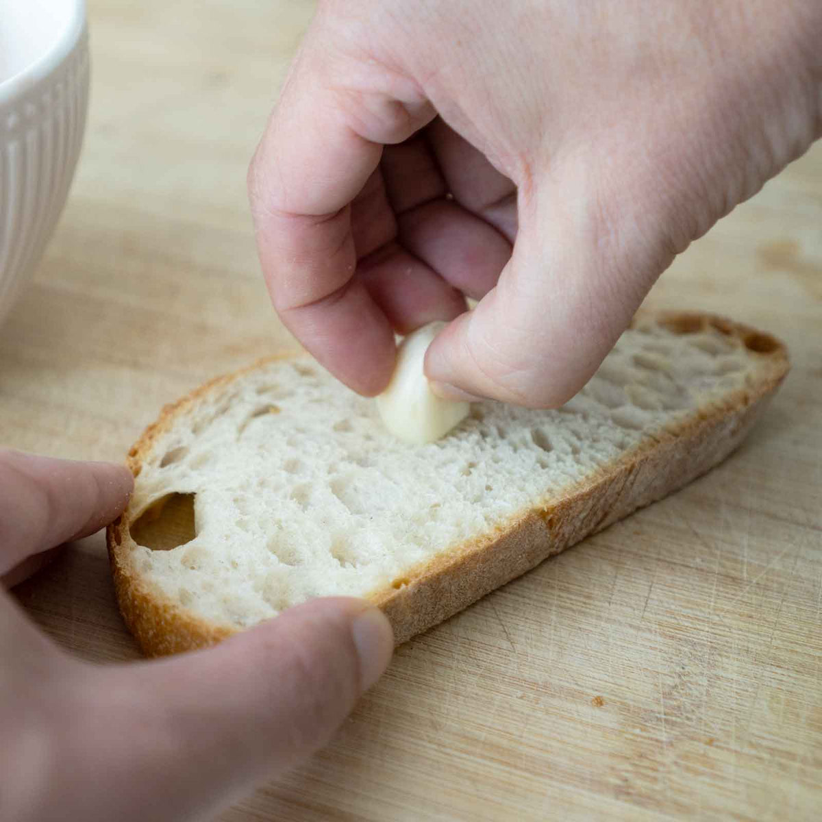 Weißbrot wird mit Knoblauch eingerieben