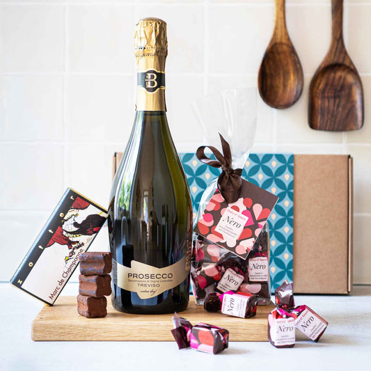 Geschenk mit süßen Trüffeln, Schokolade und Prosecco