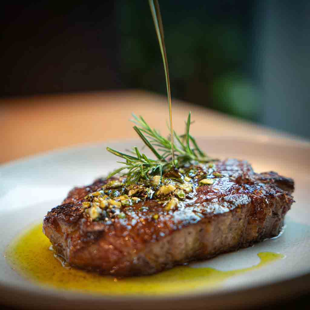 Verfeinerung eines Steaks mit intensiv-fruchtigem Olivenöl
