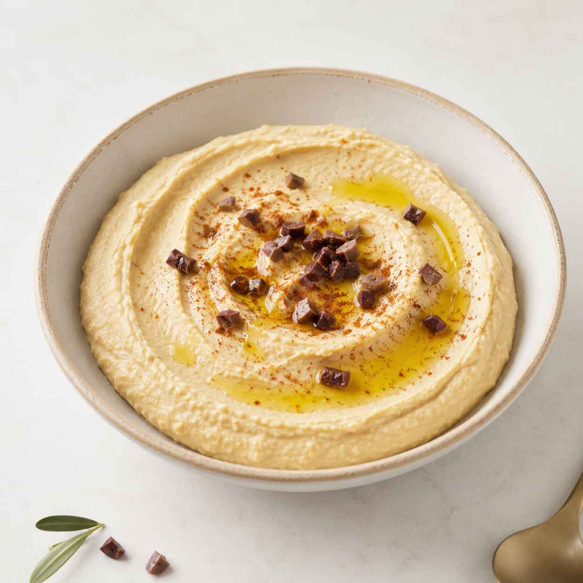 Hummus mit Arganöl-Topping und gehackten Oliven