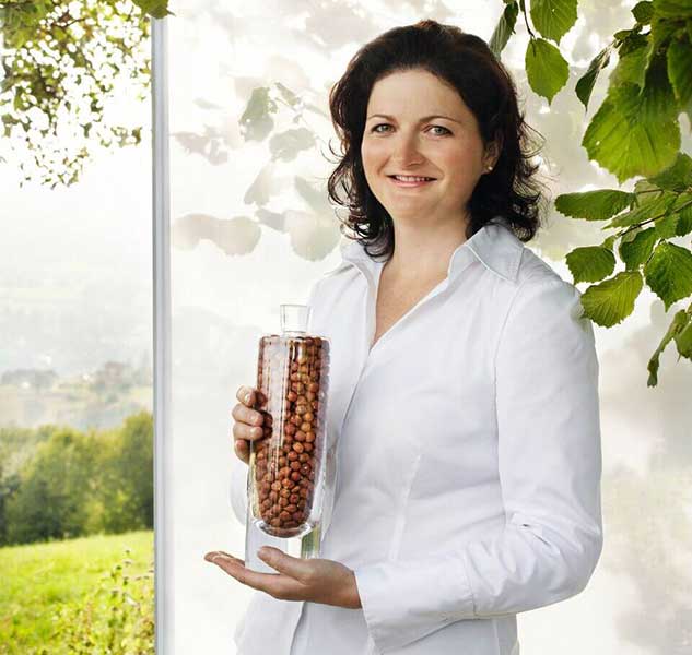 Frau hält Glas mit Nüssen.