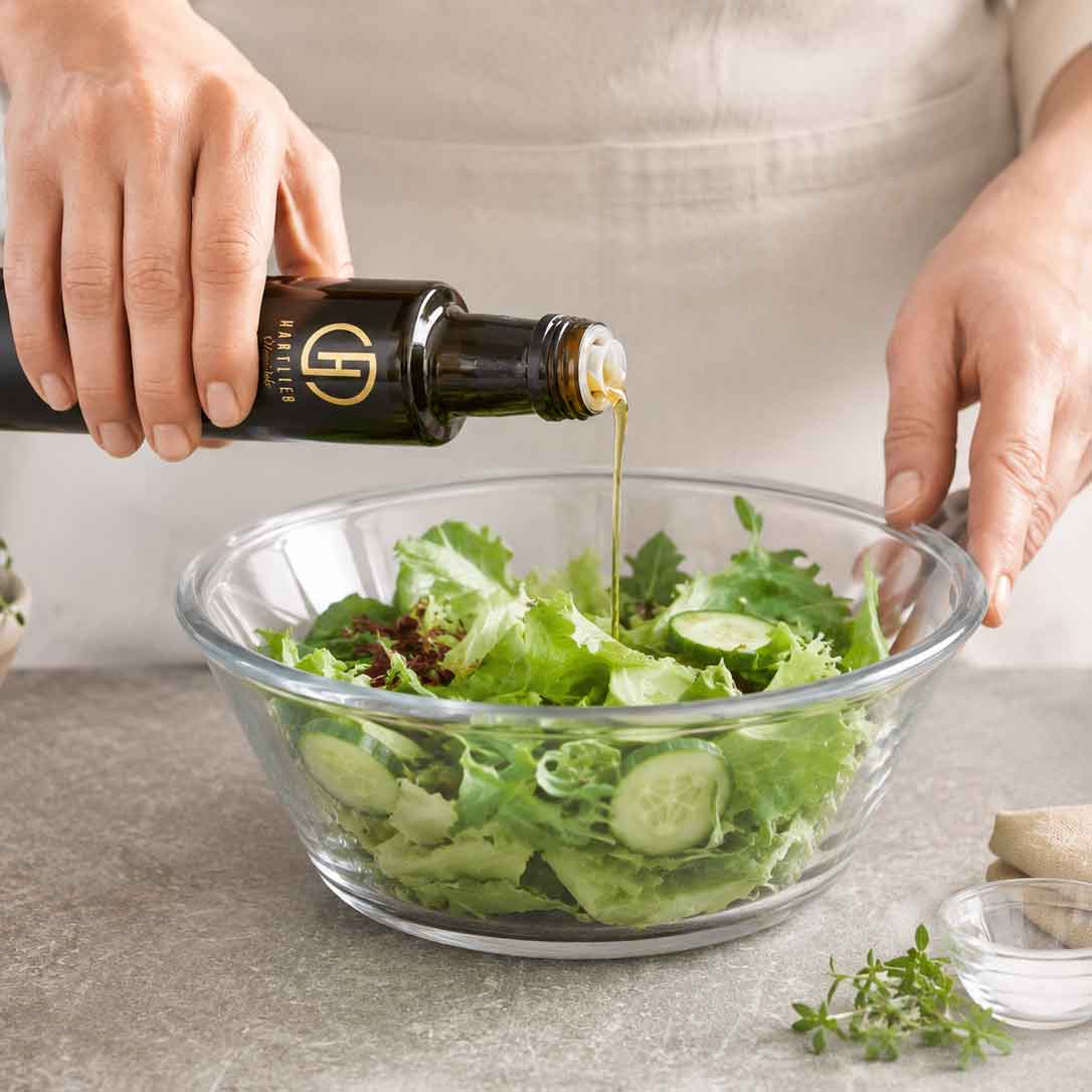 Leinöl wird über einen grünen Blattsalat gegeben