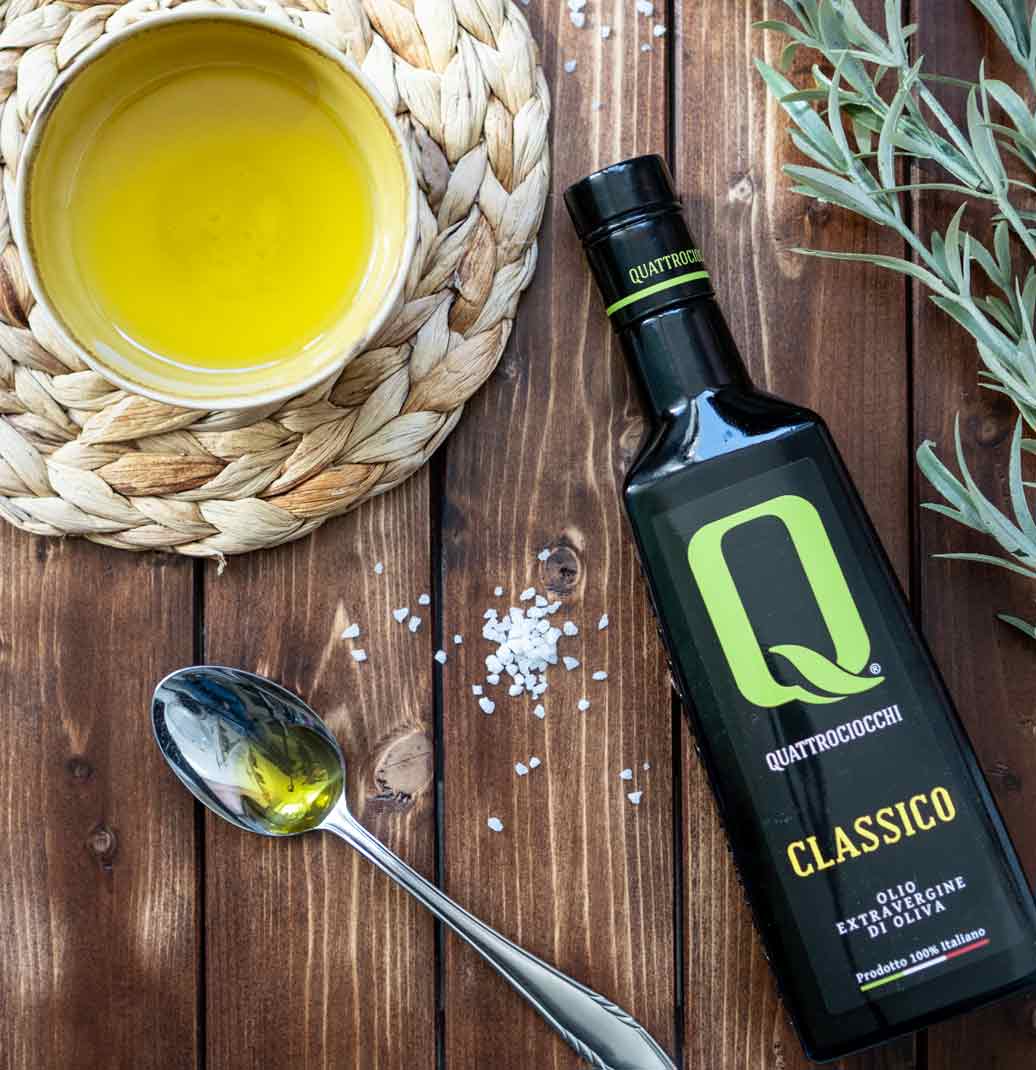 Quattrociocchi Classico Olivenölflasche, Schale, Löffel, Holzuntergrund, Salz.