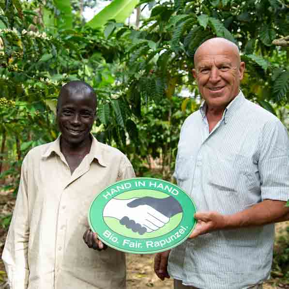 Zwei Männer mit Fair-Trade-Schild.