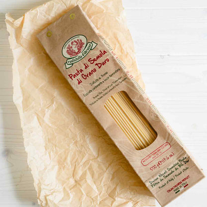 Rustichella Pasta Spaghetti auf Papierunterlage, Verpackung sichtbar.