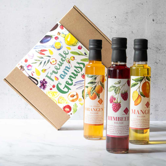Drei Flaschen Balsamico vor Geschenkbox mit "Freude am Genuss".