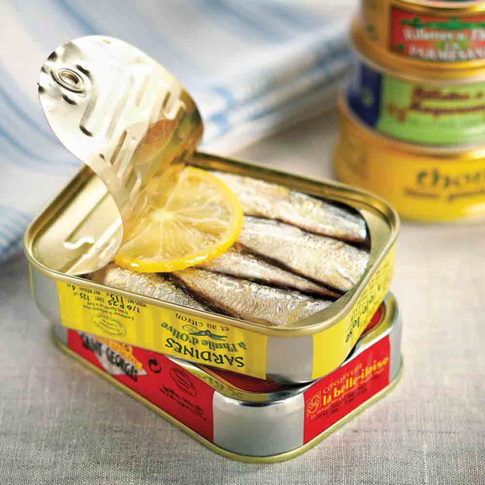 Sardinen in Olivenöl mit Zitrone, vier Dosen sichtbar.
