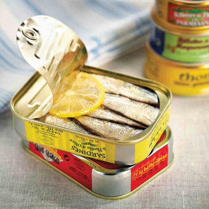 Sardinen in Olivenöl mit Zitrone, vier Dosen sichtbar.