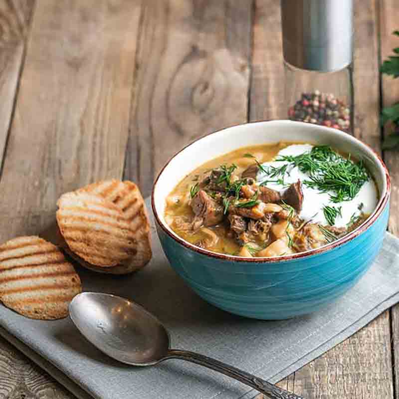 Suppe mit Pilzen und Brot.